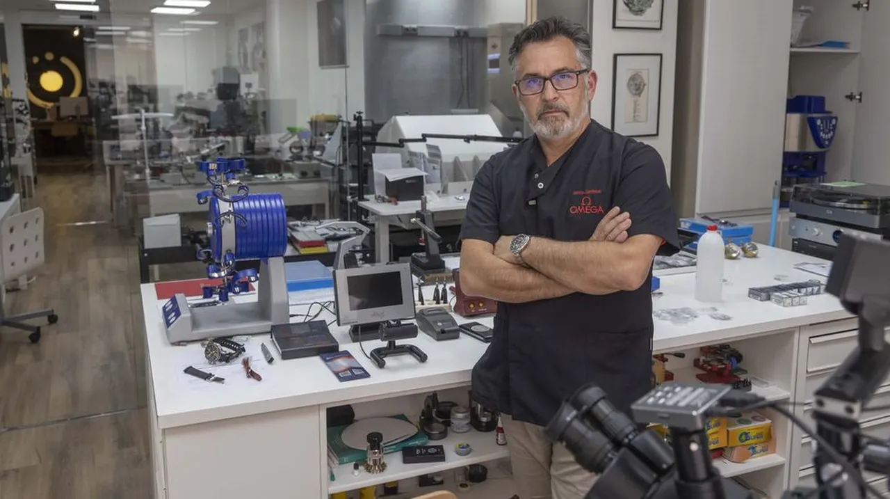 Luis Míguez de pie en su taller de relojería de Ordes junto al equipamiento especializado